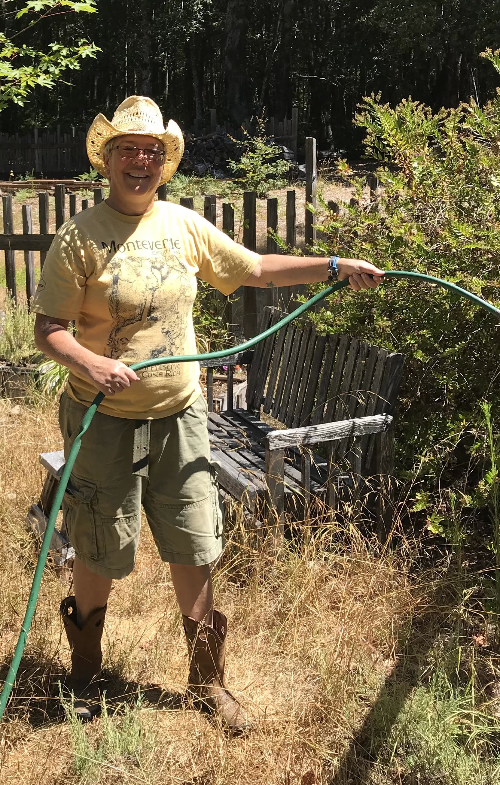 Amy Righter tending a garden with a hose