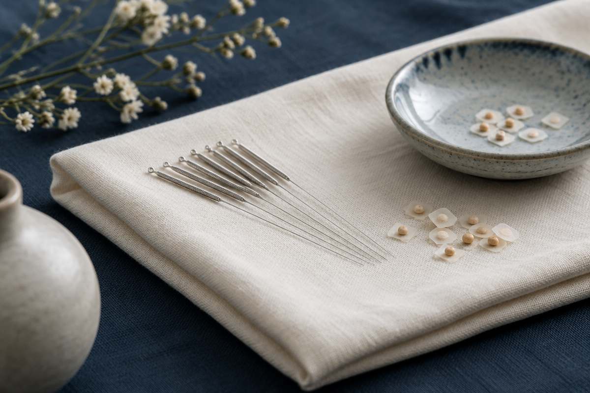 Fine needles and ear seeds arranged on ivory linen